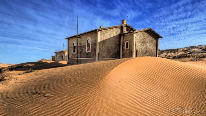 Kolmanskop houses in the desert with blue sky